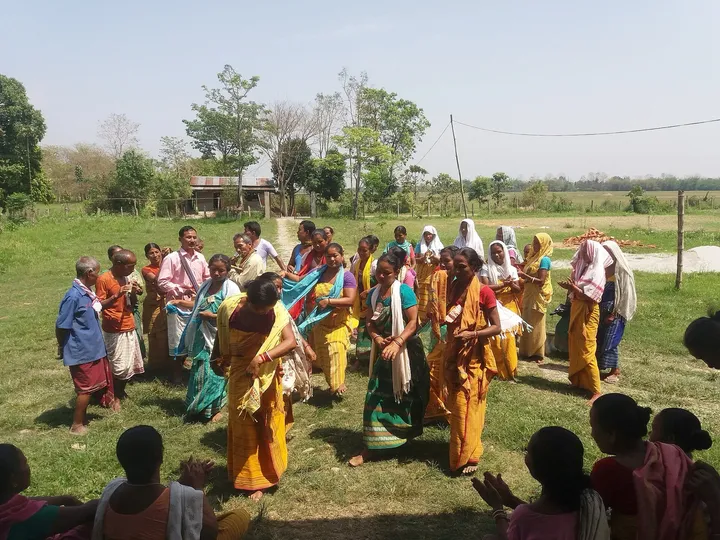 Bodo dancers in traditional dress performing Bwisagu in a field