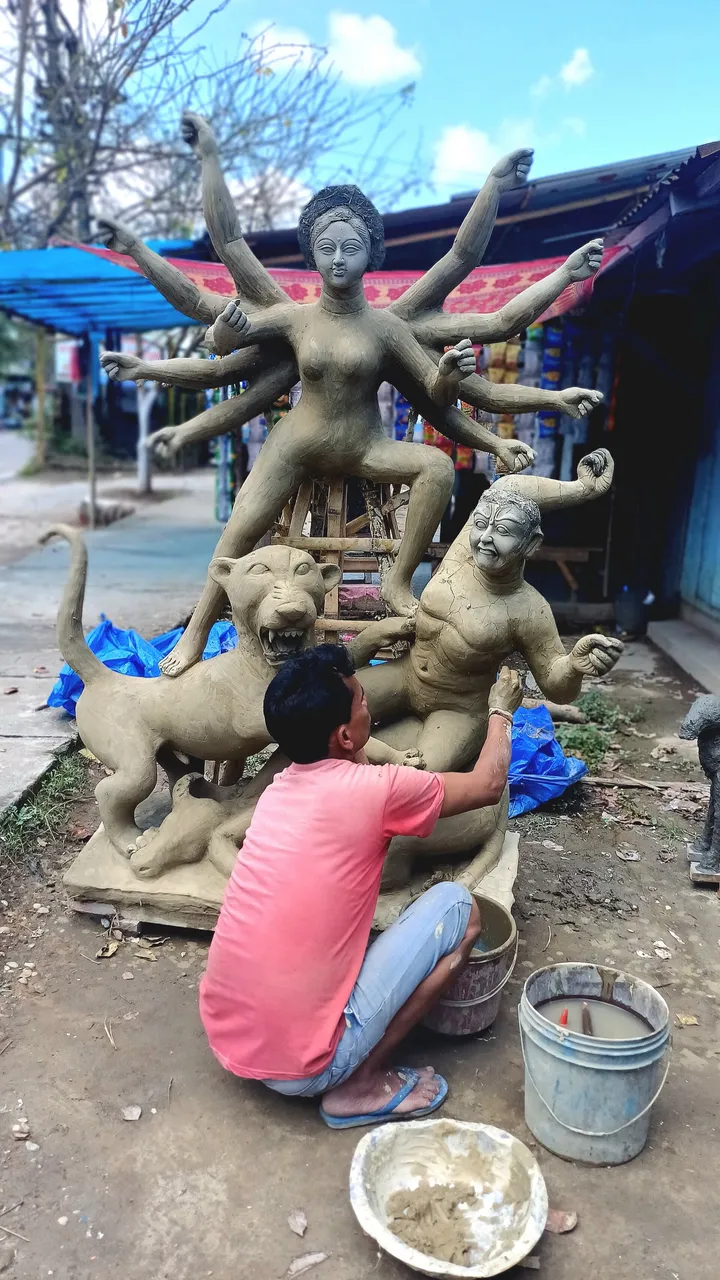 An artisan sculpting a Durga idol