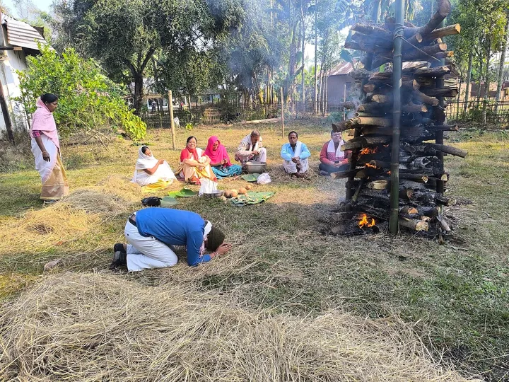 A meji burning on the morning after Uruka, with a family seated nearby